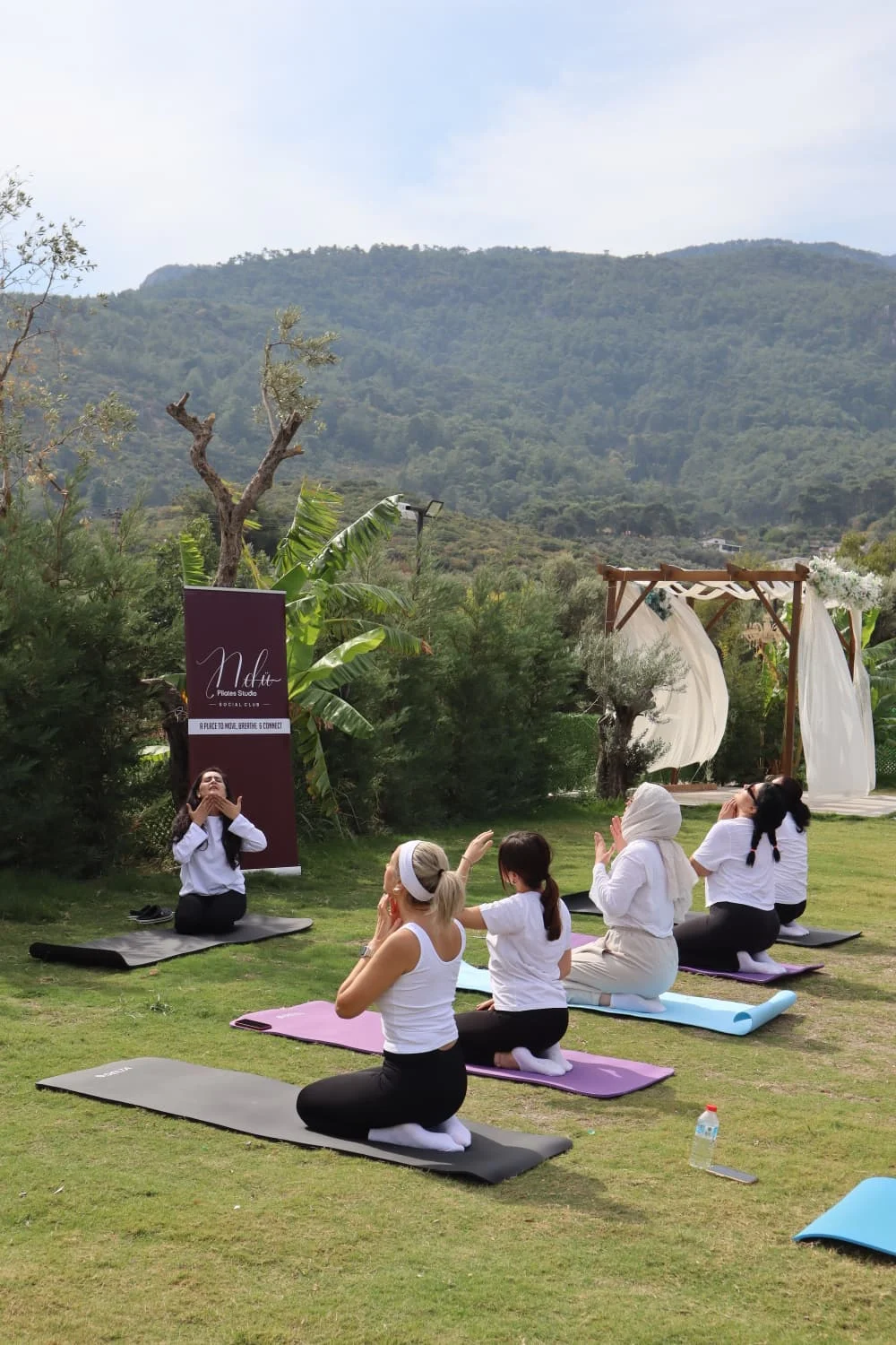 Doğada birlikte yoga yapan katılımcılar